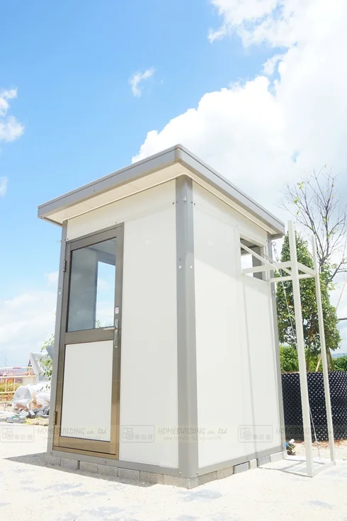 原工程 A01 的直向外觀：小型組合建築、門窗與藍天